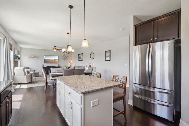 417 Champlain Dr, Johnson Creek, WI 53038 - kitchen with freestanding refrigerator, dark brown cabinets, a center island, ceiling fan, and a kitchen bar