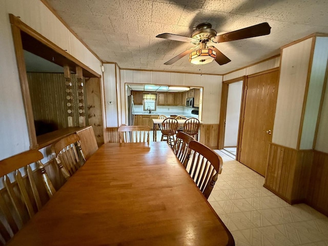105 Cliff St, Camp Douglas, WI 54618 - dining room featuring wood walls, a ceiling fan, and light floors