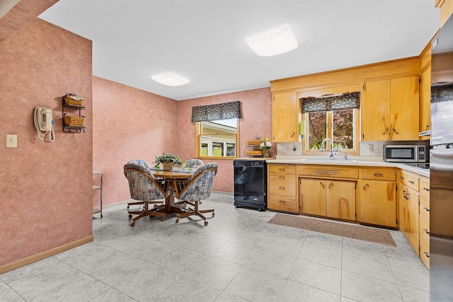 904 S Hamlin St, Shawano, WI 54166 - kitchen with black dishwasher, a sink, stainless steel microwave, light countertops, and backsplash