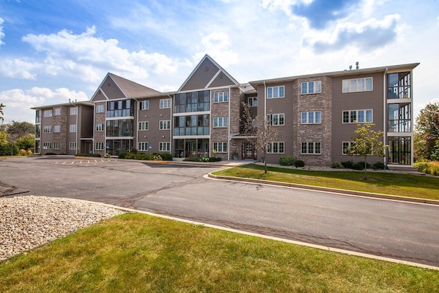 211 Oconomowoc Pkwy, Oconomowoc, WI 53066 - view of apartment building / complex featuring uncovered parking
