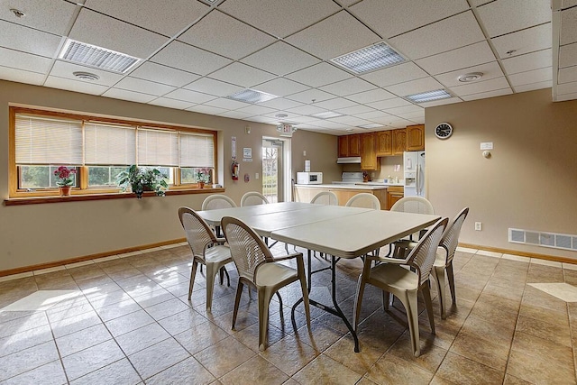 211 Oconomowoc Pkwy, Oconomowoc, WI 53066 - dining area featuring a drop ceiling, light tile patterned floors, and baseboards