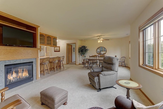 211 Oconomowoc Pkwy, Oconomowoc, WI 53066 - living room with ceiling fan, light colored carpet, a glass covered fireplace, and baseboards