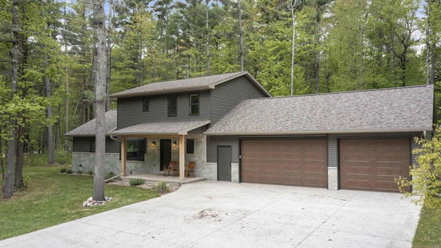 W2434 Timber Trl, Keshena, WI 54135 - view of front of house with a garage, concrete driveway, a porch, a front lawn, and a shingled roof