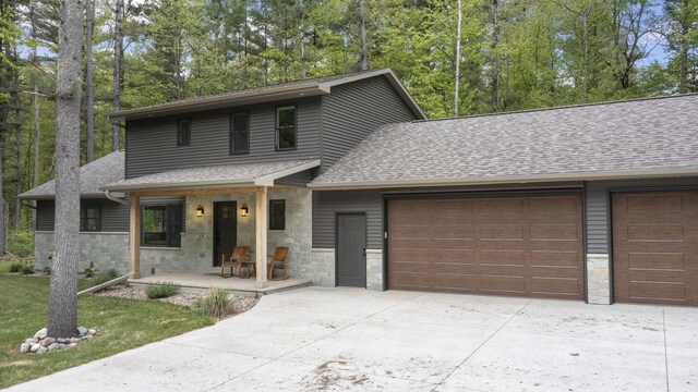 W2434 Timber Trl, Keshena, WI 54135 - view of front of house featuring a garage, concrete driveway, and stone siding