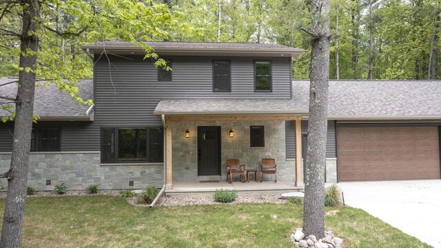 W2434 Timber Trl, Keshena, WI 54135 - view of front of home featuring covered porch, a garage, roof with shingles, concrete driveway, and a front lawn