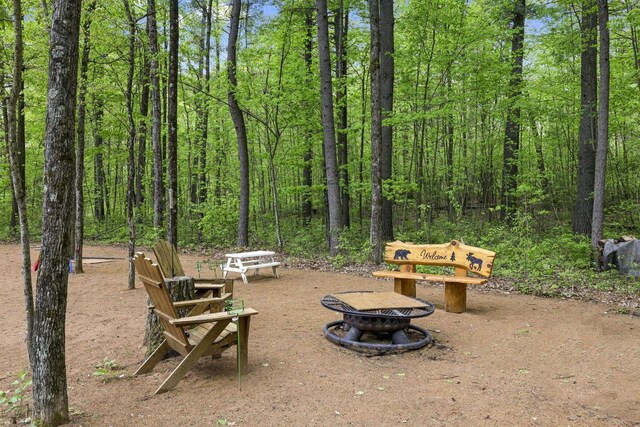 W2434 Timber Trl, Keshena, WI 54135 - view of yard with an outdoor fire pit and a forest view