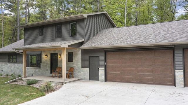 W2434 Timber Trl, Keshena, WI 54135 - view of front of house with a shingled roof, an attached garage, and stone siding