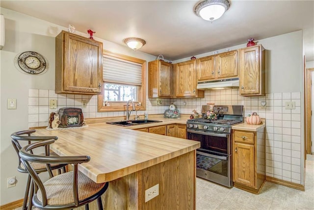 E5777 689th Ave, Menomonie, WI 54751 - kitchen with double oven range, under cabinet range hood, a sink, a peninsula, and a kitchen bar