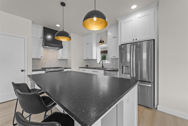 727 Schubert St, Verona, WI 53593 - kitchen featuring wall chimney exhaust hood, stainless steel appliances, a sink, dark countertops, and light wood-type flooring