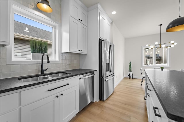 727 Schubert St, Verona, WI 53593 - kitchen featuring stainless steel appliances, a sink, tasteful backsplash, light wood-type flooring, and white cabinetry