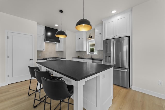 727 Schubert St, Verona, WI 53593 - kitchen with appliances with stainless steel finishes, dark countertops, light wood-type flooring, white cabinets, and backsplash