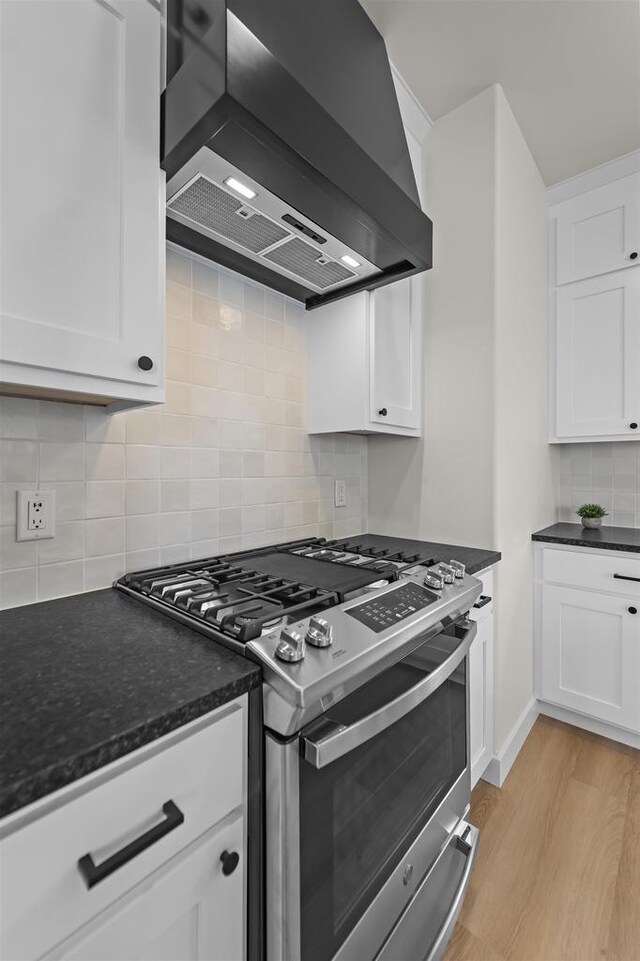 727 Schubert St, Verona, WI 53593 - kitchen with gas stove, wall chimney exhaust hood, backsplash, and white cabinetry
