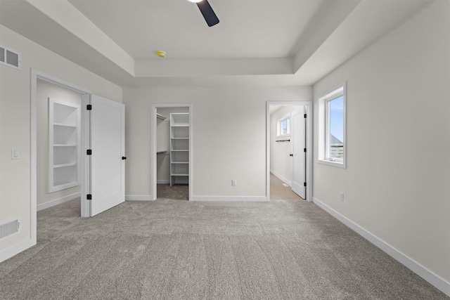 727 Schubert St, Verona, WI 53593 - unfurnished bedroom with a tray ceiling, carpet, a walk in closet, baseboards, and connected bathroom