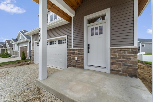 727 Schubert St, Verona, WI 53593 - view of exterior entry featuring stone siding and a garage