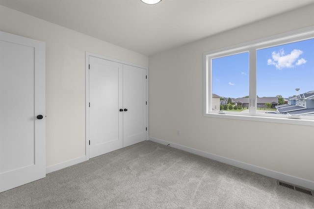 727 Schubert St, Verona, WI 53593 - unfurnished bedroom featuring light carpet, baseboards, a closet, and a residential view