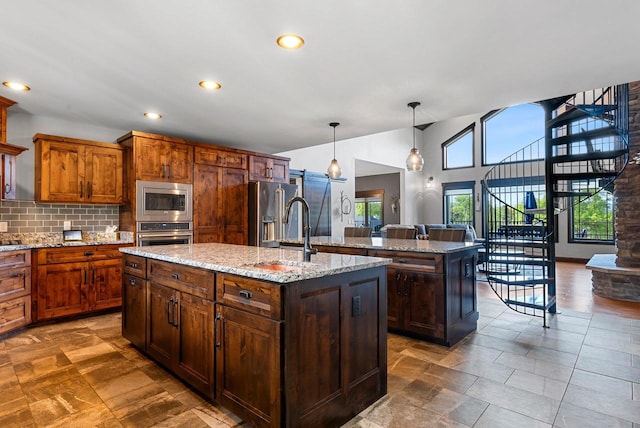 E12603 Bay Rd, Merrimac, WI 53561 - kitchen with stainless steel appliances, a center island with sink, a sink, tasteful backsplash, and decorative light fixtures