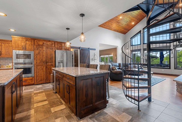 E12603 Bay Rd, Merrimac, WI 53561 - kitchen with stainless steel appliances, a barn door, open floor plan, high vaulted ceiling, and a kitchen island