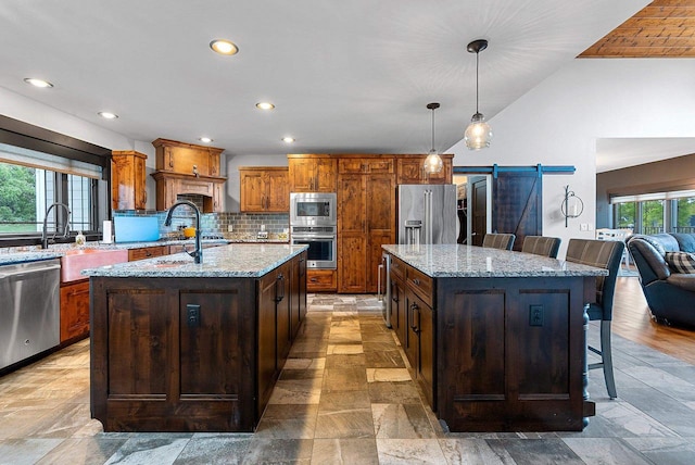 E12603 Bay Rd, Merrimac, WI 53561 - kitchen with a center island with sink, stainless steel appliances, a barn door, stone tile flooring, and lofted ceiling