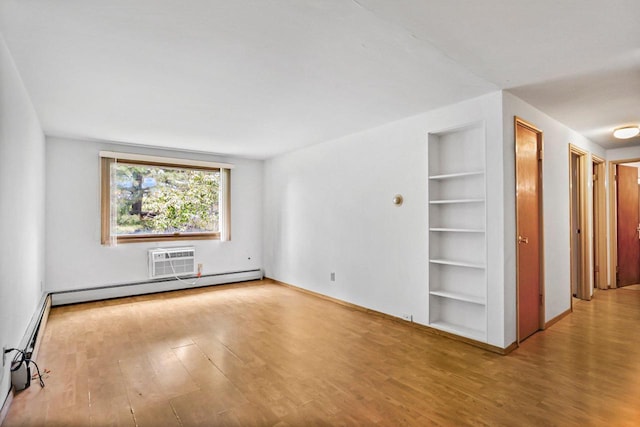 1923 Sherman Ave, Madison, WI 53704 - spare room with wood finished floors, built in shelves, a baseboard radiator, and baseboards