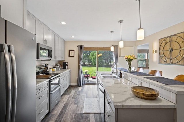 1115 Daniel Ct Unit 40, Neenah, WI 54956 - kitchen featuring stainless steel appliances, a sink, dark wood-style flooring, decorative backsplash, and recessed lighting