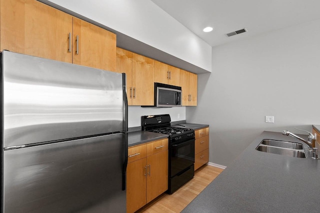 101 Cherry St Unit 208, Green Bay, WI 54301 - kitchen featuring appliances with stainless steel finishes, a sink, light wood-style floors, dark countertops, and baseboards