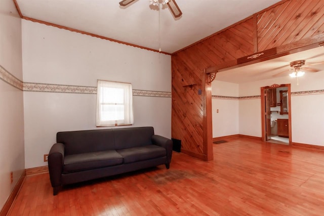 302 W Division St, Fond Du Lac, WI 54935 - living room with ceiling fan, wood finished floors, baseboards, wood walls, and ornamental molding