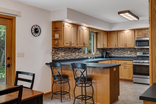 N17795 Trim Rd, Galesville, WI 54630 - kitchen featuring stainless steel appliances, dark countertops, a kitchen breakfast bar, a peninsula, and backsplash