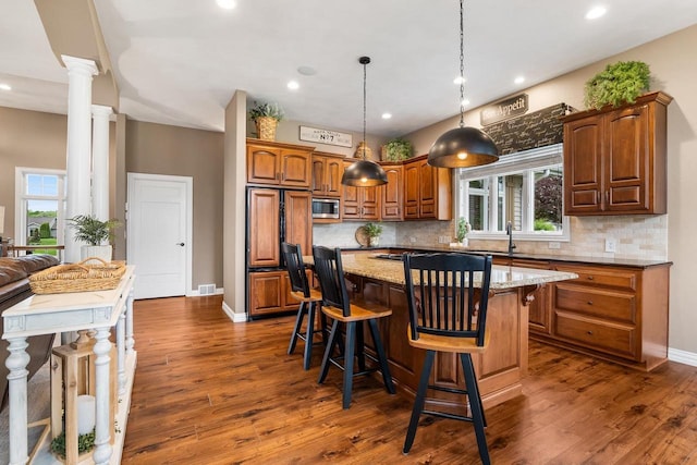 W4825 Wild Wings Dr, Sherwood, WI 54169 - kitchen featuring built in appliances, decorative backsplash, ornate columns, light stone counters, and healthy amount of natural light