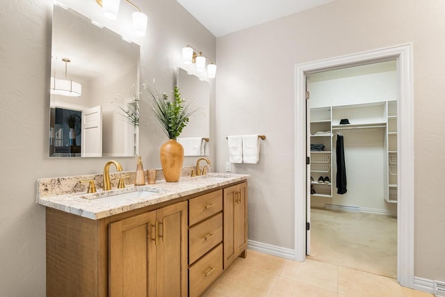 W4825 Wild Wings Dr, Sherwood, WI 54169 - bathroom with double vanity, tile patterned flooring, a walk in closet, and baseboards