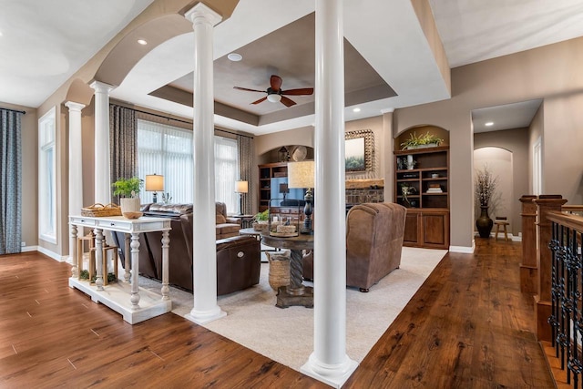 W4825 Wild Wings Dr, Sherwood, WI 54169 - living room featuring a ceiling fan, decorative columns, wood finished floors, a tray ceiling, and baseboards