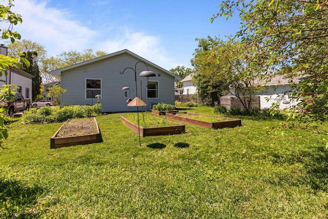 1242 Liberty St, Oshkosh, WI 54901 - rear view of house featuring a garden and a lawn