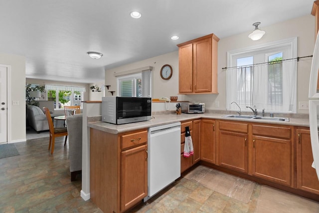 1242 Liberty St, Oshkosh, WI 54901 - kitchen with white dishwasher, stainless steel microwave, a peninsula, a sink, and light countertops