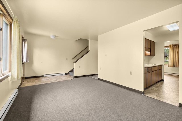 521 E Grand Ave, Rosholt, WI 54473 - unfurnished room featuring baseboard heating, a baseboard radiator, light carpet, and stairs