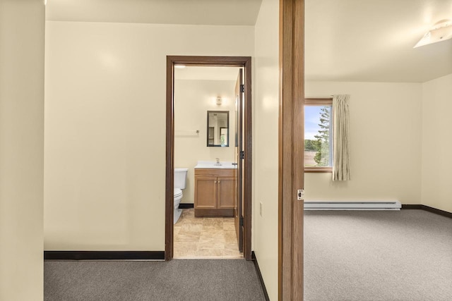 521 E Grand Ave, Rosholt, WI 54473 - hallway featuring baseboard heating, carpet, a sink, and baseboards
