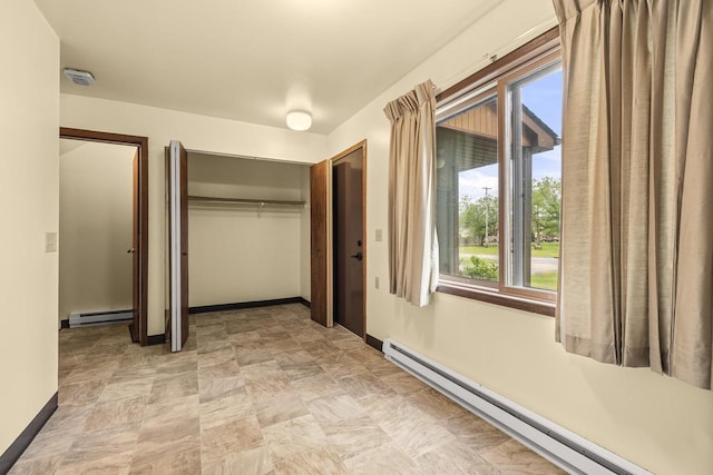 521 E Grand Ave, Rosholt, WI 54473 - unfurnished bedroom with a baseboard radiator, multiple windows, and baseboards