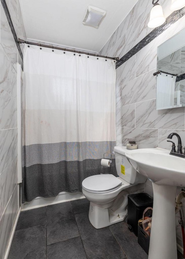 2801 Harvey St, La Crosse, WI 54603 - bathroom featuring tile walls, toilet, and curtained shower