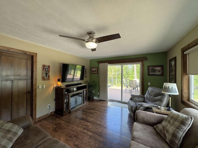 N3140 Forest Prairie Park Rd, Monroe, WI 53566 - living room with dark wood-type flooring, baseboards, ceiling fan, and a glass covered fireplace