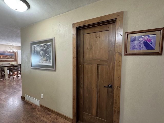 N3140 Forest Prairie Park Rd, Monroe, WI 53566 - hall featuring a chandelier, dark wood-style flooring, baseboards, and a textured wall