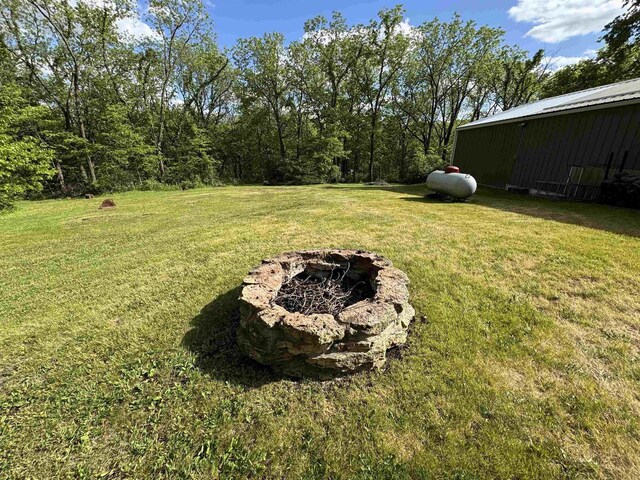 N3140 Forest Prairie Park Rd, Monroe, WI 53566 - view of grassy yard featuring a fire pit and an outbuilding