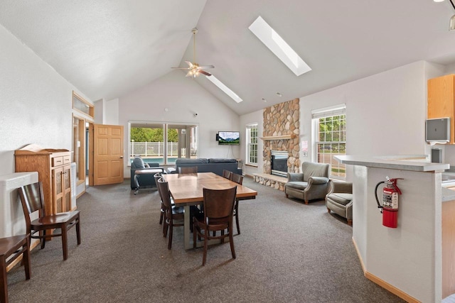 10 Kings Mill Cir Unit 113, Madison, WI 53718 - dining space featuring high vaulted ceiling, a fireplace, a skylight, dark carpet, and healthy amount of natural light