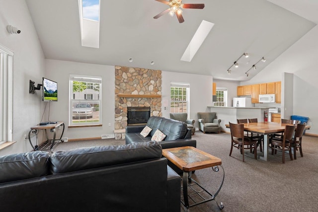 10 Kings Mill Cir Unit 113, Madison, WI 53718 - carpeted living area featuring a skylight, healthy amount of natural light, a ceiling fan, a stone fireplace, and high vaulted ceiling