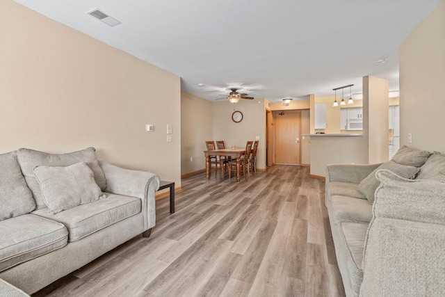 10 Kings Mill Cir Unit 113, Madison, WI 53718 - living area featuring light wood finished floors, a ceiling fan, and baseboards