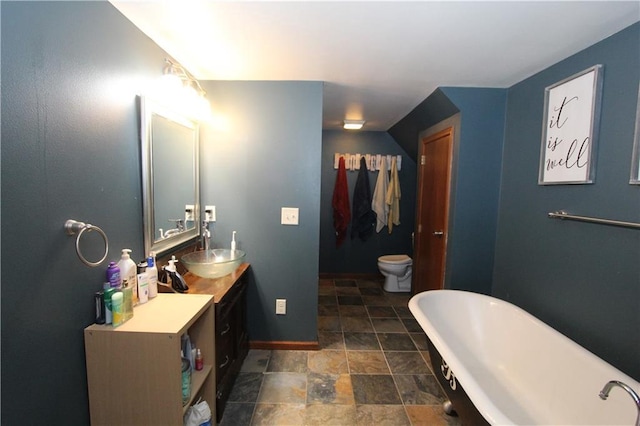 1808 Curtiss St, Eau Claire, WI 54703 - full bathroom featuring a freestanding bath, stone finish flooring, vanity, baseboards, and toilet