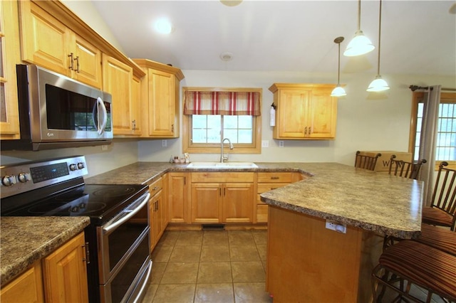 1808 Curtiss St, Eau Claire, WI 54703 - kitchen with stainless steel appliances, a sink, a breakfast bar area, a peninsula, and hanging light fixtures