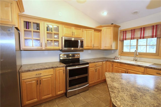 1808 Curtiss St, Eau Claire, WI 54703 - kitchen featuring stainless steel appliances, a sink, vaulted ceiling, light tile patterned floors, and glass insert cabinets