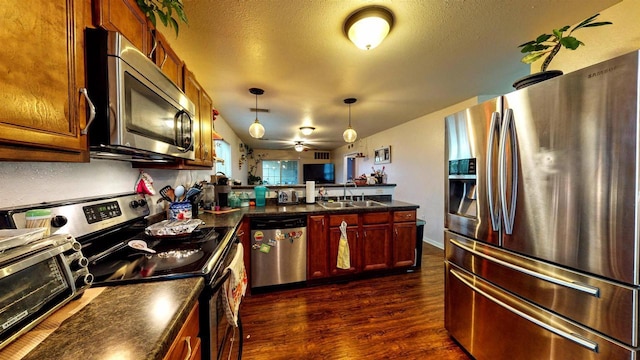 619 Reena Ave Unit 8, Fort Atkinson, WI 53538 - kitchen featuring stainless steel appliances, a sink, a peninsula, dark countertops, and a textured ceiling