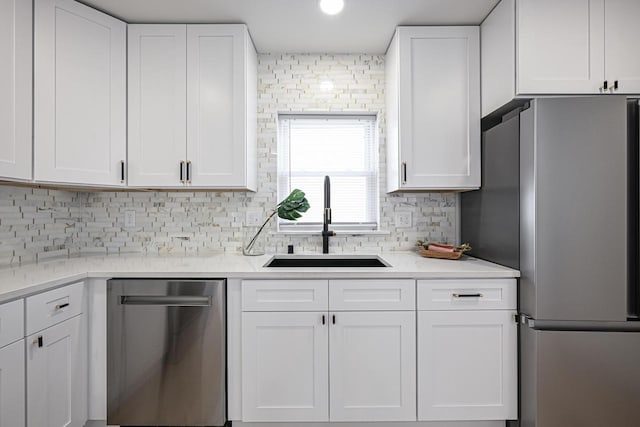 1922 E Iron St, Milwaukee, WI 53207 - kitchen featuring stainless steel appliances, a sink, white cabinets, light countertops, and decorative backsplash