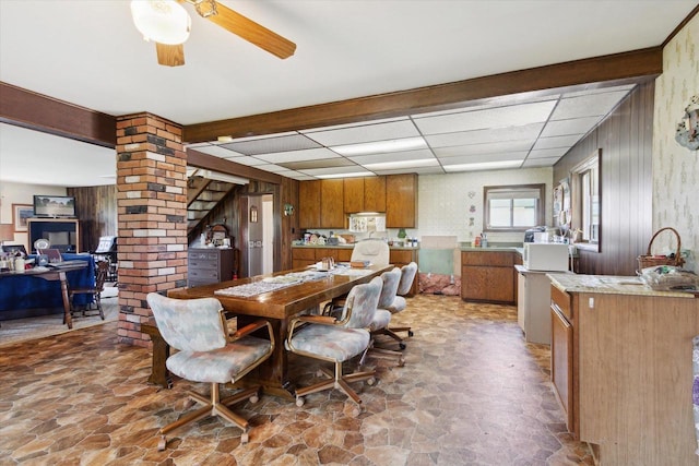 N1815 County Road T, Brodhead, WI 53520 - dining space with stone floors, a drop ceiling, a ceiling fan, an office area, and wooden walls