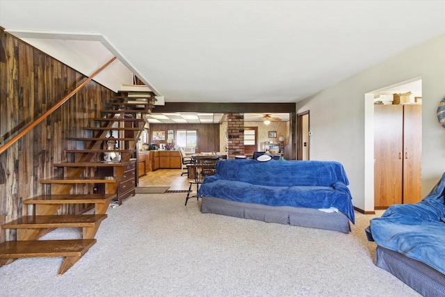 N1815 County Road T, Brodhead, WI 53520 - living room featuring light carpet, stairway, ceiling fan, and wooden walls