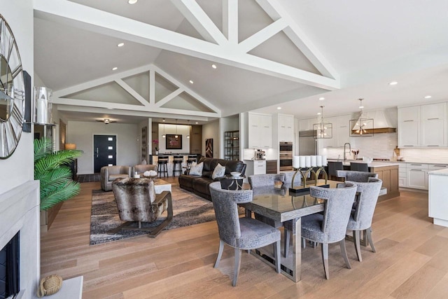7678 Badger Run Ct, Verona, WI 53593 - dining area featuring high vaulted ceiling, recessed lighting, light wood-type flooring, and a fireplace
